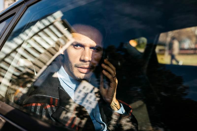 A man sitting in car sunrays shining on his face